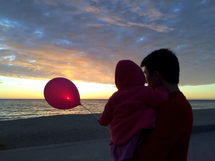 Atardecer en la playa con mi hija y un globo rojo