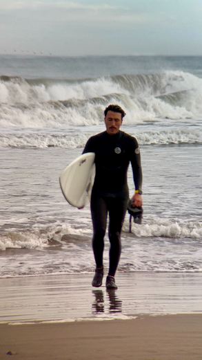 Saliendo del agua con tabla de surf